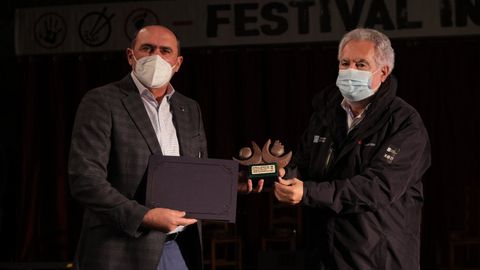 Anxo Angueira recoge el premio de manos del presidente del Parlamento de Galicia, Miguel Santalices