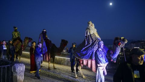 Con la caída de la noche, la luna llena acompañó el recorrido de los Reyes Magos, a su paso por el puente romano de Ourense.