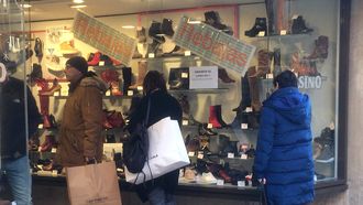 Compradores miran un escaparate con rebajas en el centro de Oviedo