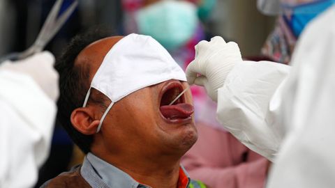 En Bogor, Indonseia, un sanitario toma una muestra de hisopo en una prueba de covid-19
