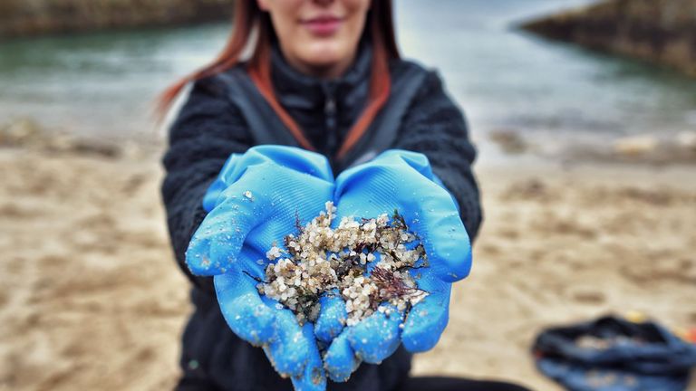 Una voluntaria limpiando de pélets la playa coruñesa de O Portiño