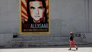 Una mujer paseando en Caracas ante un cartel que pide la libertad de Álex Saab.