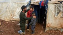 Ahmad Hamra y sus hijos fuera ante su tienda de campaa en un campamento sirio para desplazados, en el norte de Alepo