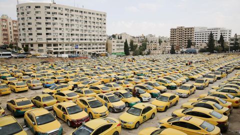 Vista de cientos de taxis aparcados frente al Parlamento durante una protesta de los profesionales del sector contra la actividad de los vehículos de alquiler con conductor (VTC), en Amán, Jordania.