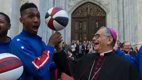 El obispo Dominick Lagonegro realiza malabarismos con un baln de baloncesto con la ayuda de los Harlem Globetrotters frente a la fachada principal de la catedral de San Patricio, en Nueva York. 