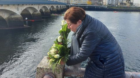 La madre de Keny, Rosalía Balchada, depositando un ramo de flores a orillas del río.