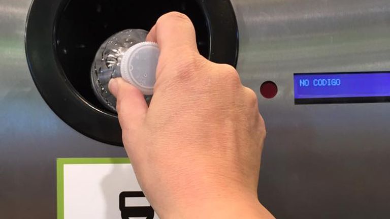 Un usuario utiliza una máquina de recogida de residuos para reciclar