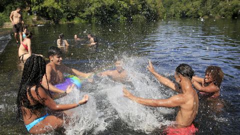 Jóvenes disfrutando de un baño en el Piago