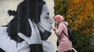 Una persona pasa por delante de una de las obras del artista Sentydo ART de la campaa dedicada a los besos sin mascarillas en Oviedo