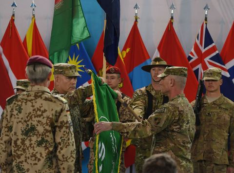 El general estadounidense John Campbell pliega la bandera de la ISAF en un acto en Kabul.
