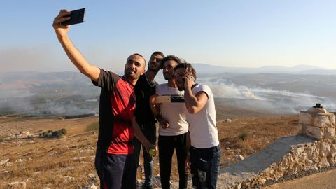Varios jvenes se hacen un selfi 
La gente se toma selfies en el lugar donde cayeron proyectiles disparados desde Israel en la aldea Maroun al Ras