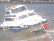 ...Barco agujereado por el temporal tras golpear contra las rocas en Aldan