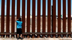 Un nio mexicano mira a travs del muro que separa a su pas de Estados Unidos en Calexico (California)