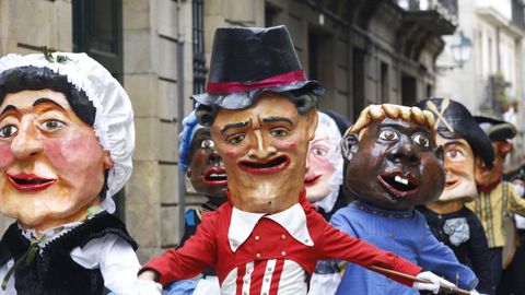 Unos cabezudos desfilan por las calles de Santiago