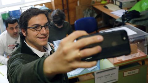 El candidato de Vox al Congreso por Asturias, José María Figaredo, se hace un selfi en la mesa electoral del colegio Pablo Miaja de Oviedo, en la que votó a primera hora de la mañana