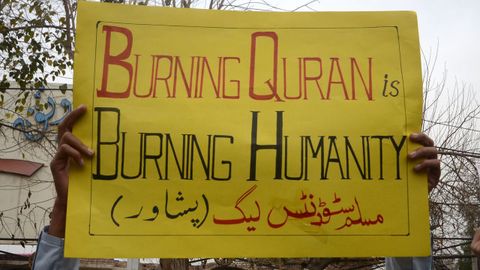 Supporters of the Muslim Men's League party hold a banner with an inscription in Urdu 