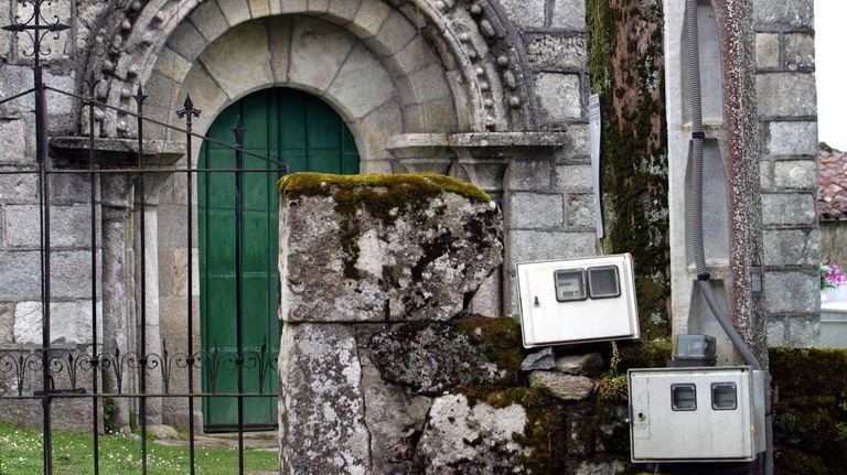 Contadores de la luz a la entrada de una iglesia románica, en una imagen de archivo