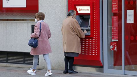 Una mujer saca dinero en un cajero del Banco Santander en Pontevedra