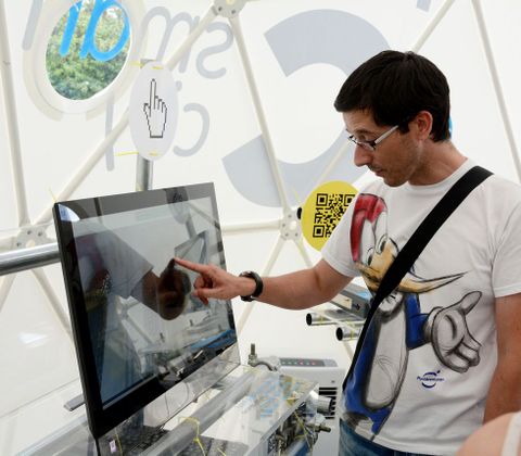 Un visitante examina un ordenador en una carpa de Smart City instalada en el Obelisco. 