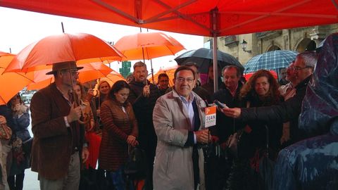 Juan Vzquez inicia la campaa en Gijn, acompaado por los miembros de su lista y protegido de la lluvia con unos llamativos paraguas naranja