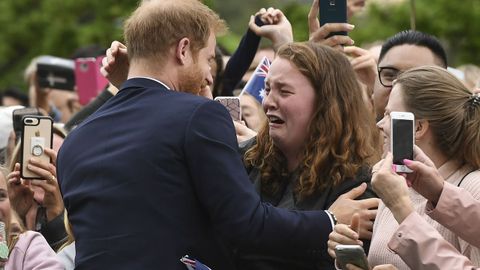 Miles de fans de la familia real inglesa esperaron bajo la lluvia en Melbourne para ver al prncipe Harry y a su esposa embarazada Meghan