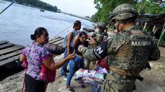 Un miembro de la polica naval procede a la identificacin de una mujer guatemalteca que cruz el ro Suchiate en una balsa desde Tecun Uman, en Guatemala, hasta Ciudad Hidalgo