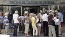 Un grupo de visitantes hace cola a las puertas de una oficina de información turística en la ciudad de Ourense