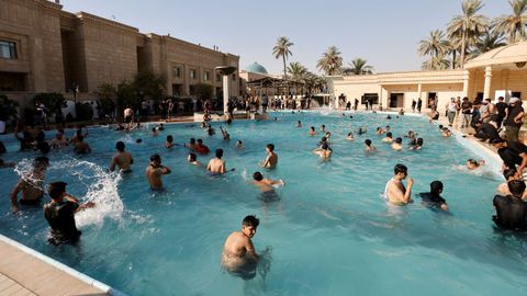 Seguidores del clérigo chií Al Sadr, este lunes, bañándose en la piscina del palacio presidencial de Bagdad