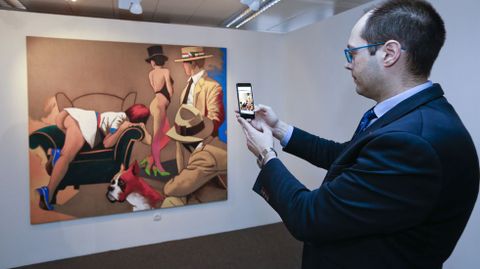 El responsable de la coleccin de arte de Abanca, Diego Cascn, muestra la aplicacin junto al cuadro de Eduardo rculo