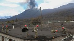 Militares del Ejrcito de Tierra limpian la ceniza de los tejados de las viviendas, en la localidad de Las Manchas, en La Palma.