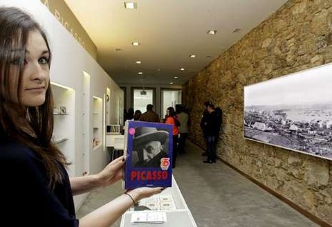 Una joven muestra un libro sobre Picasso en la casa museo del pintor en A Corua. 