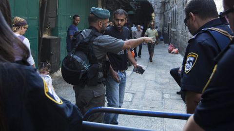Un polica fronterizo israel ordena a un palestino que se aleje de la calle cortada en el barrio musulmn de Jerusaln.