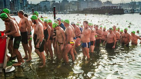 Varios nadadores compiten en la Travesa de Navidad de Gijn