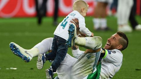 Sergios Ramos celebra la victoria sobre el cesped junto a su hijo mediano, Marco. 