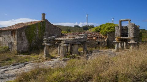 Antiguos hórreos y casas de piedra sobreviven, como buenamente pueden, en la aldea cormelana de Candelago