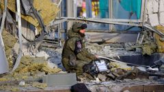 Un militar ruso ante una tienda reducida a escombros por los bombardeos en Donetsk. 