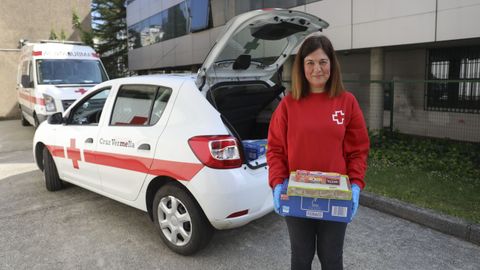 Una voluntaria de Cruz Roja reparte alimentos a las familias afectadas por la crisis en Santiago
