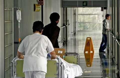 Foto de archivo del traslado de un paciente en cama por un pasillo del hospital de Monforte.