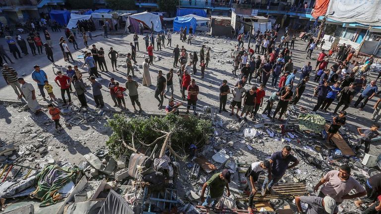 Decenas de palestinos buscan víctimas entre los escombros de la escuela de la UNRWA atacada.