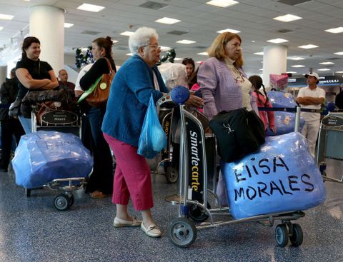 Varias personas hacen cola para embarcar en un vuelo de Miami a La Habana.