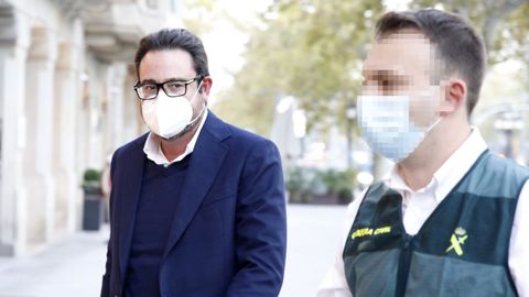 El empresario David Madí es acompañado por un agente de la Guardia Civil a su despacho en Aguas de Cataluña para ser registrada la dependencia.