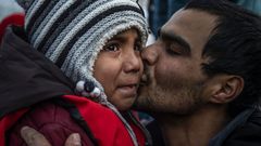 Un hombre besa a una nia que llora en la isla griega de Lesbos