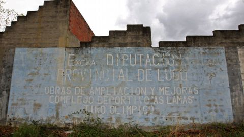 Muradl sobre la fachada del edificio del campo de tiro abandonado que recuerda que su ampliacin fue financiada por la Diputacin