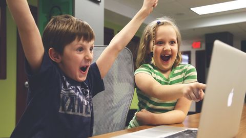 Dos niños celebran un reto conseguido en un videojuego