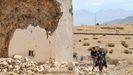 Una familia pasa junto a un edificio derruido en el cementerio de Amizmiz, a 50 kilómetros al sur de Marrakech