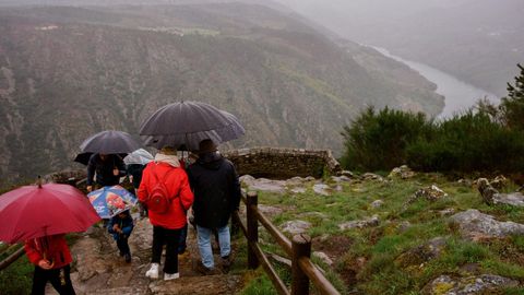 Turistas bajo la lluvia en la Ribeira Sacra