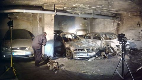 Uninvestigador de la Guardia Civil de Galicia examina los restos de un fuego en un garaje para descubrir si fue intencionado.