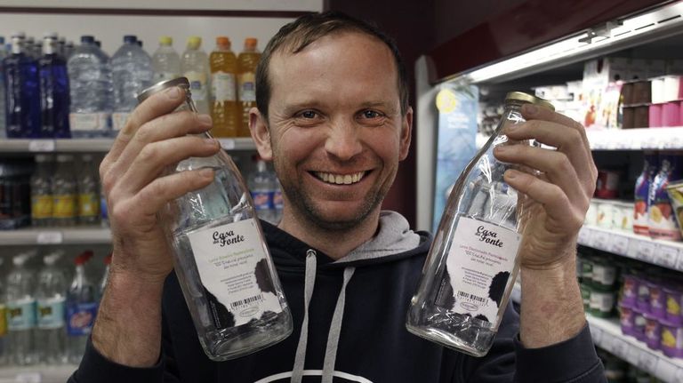 Xosé García, con dúas botellas de leite de Casa da Fonte
