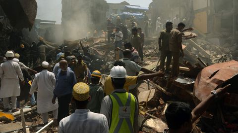 Trabajadores de rescate y residentes buscan sobrevivientes en el sitio del derrumbamiento de un edificio en Mumbai