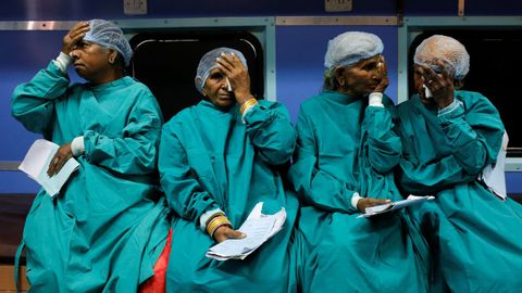 Varios pacientes se tapan los ojos antes de ser operados de cataratas en India.